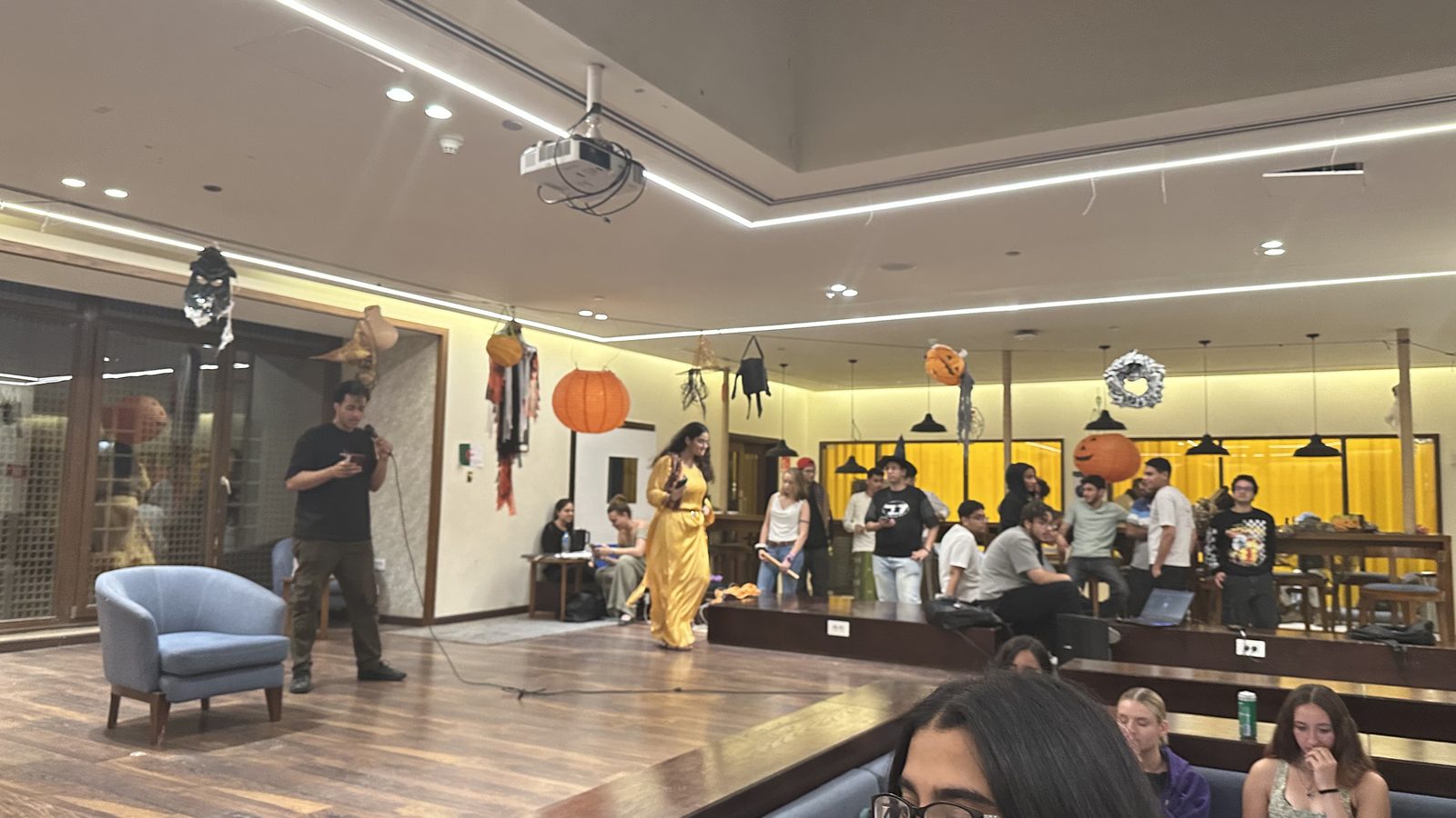 LIC members hosting a Halloween-themed cultural event with a decorated stage and pumpkins