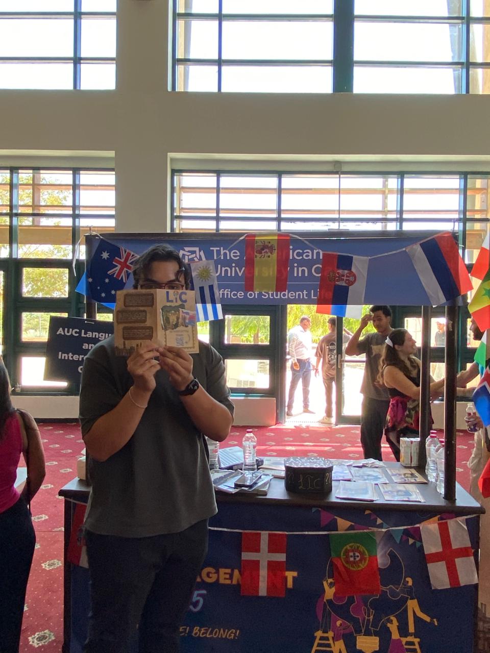 An LIC member at the booth with bunting of international flags