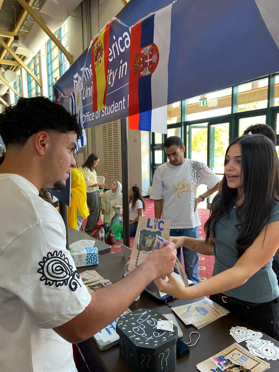 An LIC member handing a paper LIC passport to a student