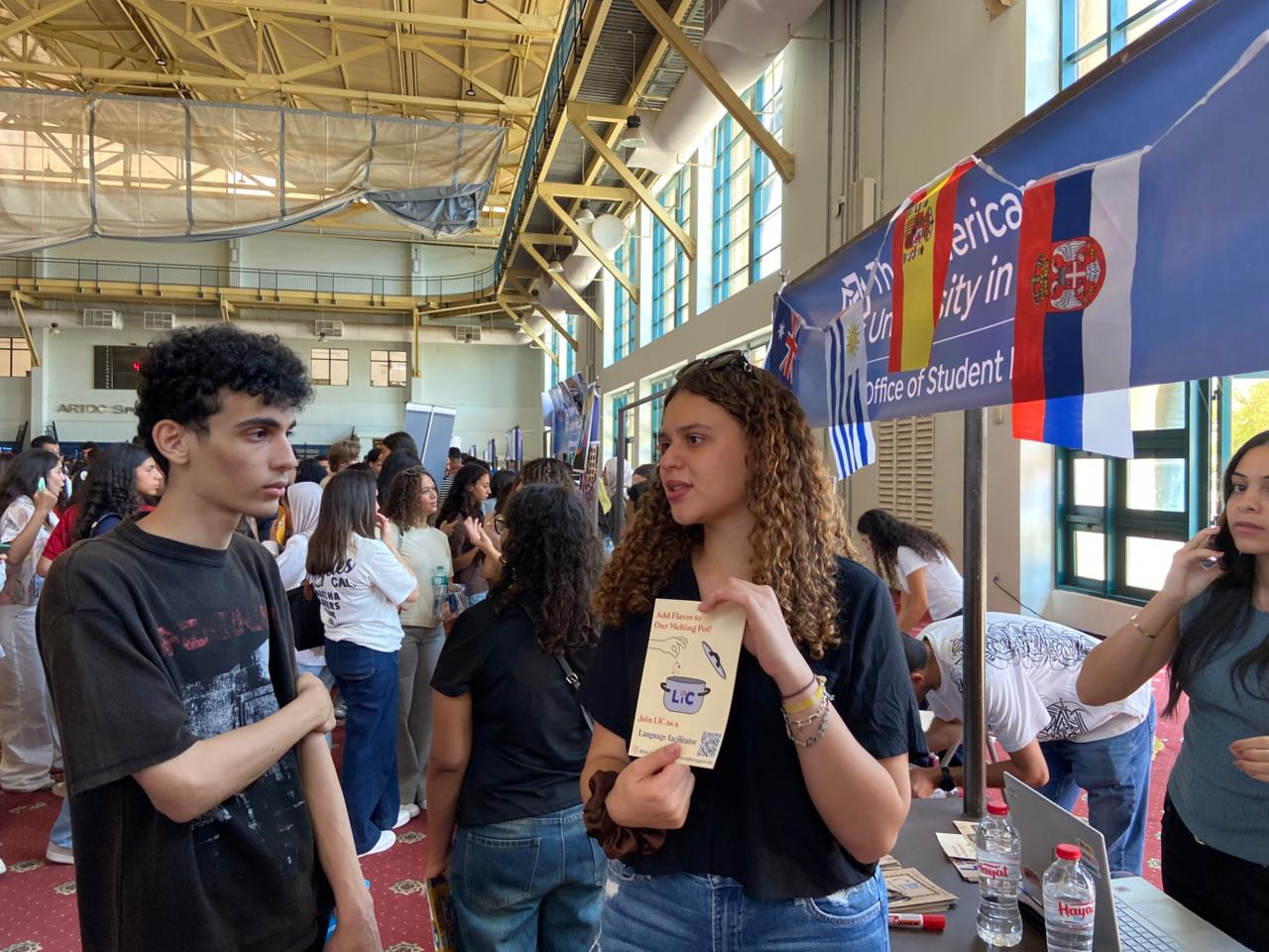 An LIC member sharing a language-facilitator flyer with a student